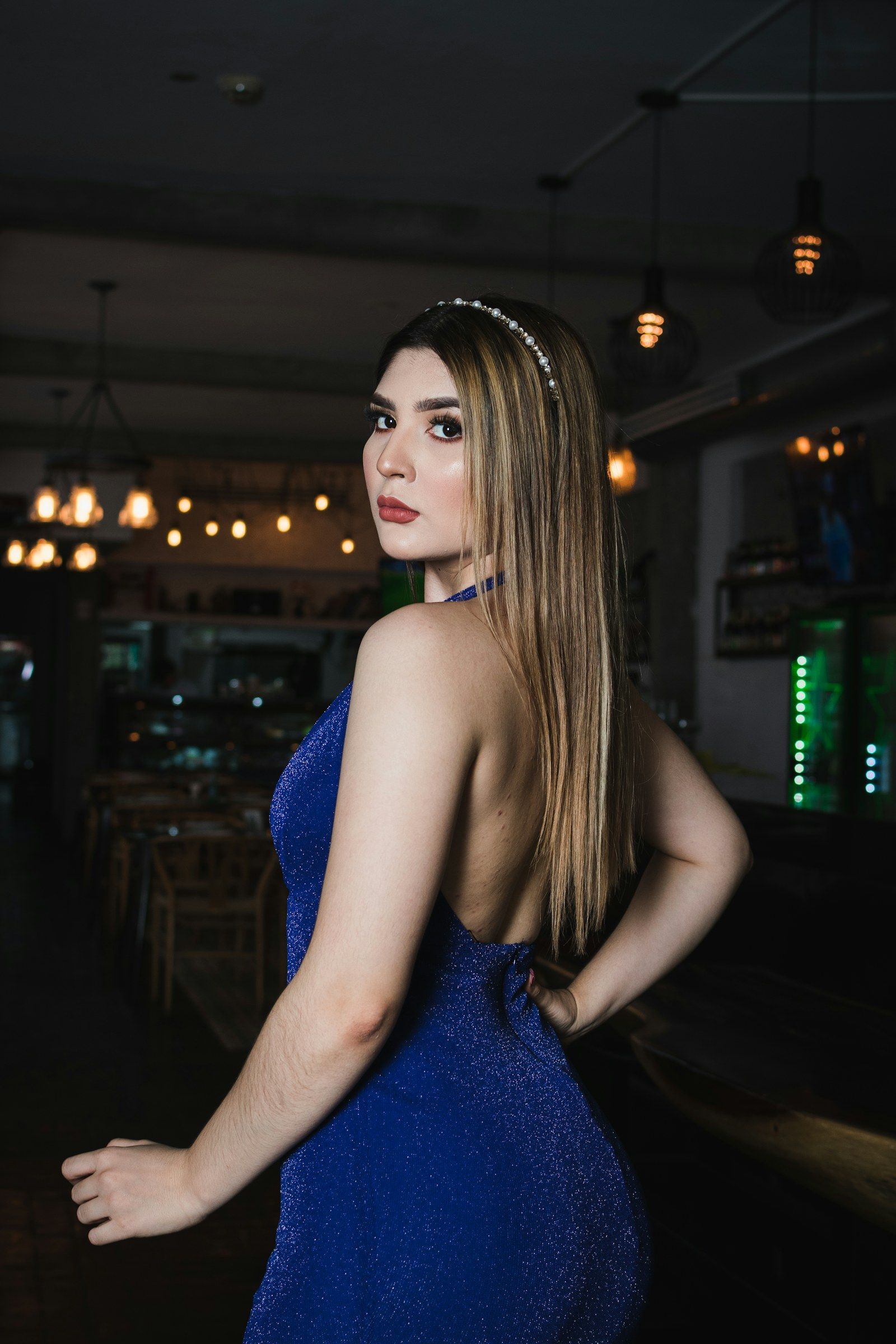 Joven con vestido de gala azul y tiara en una fiesta
