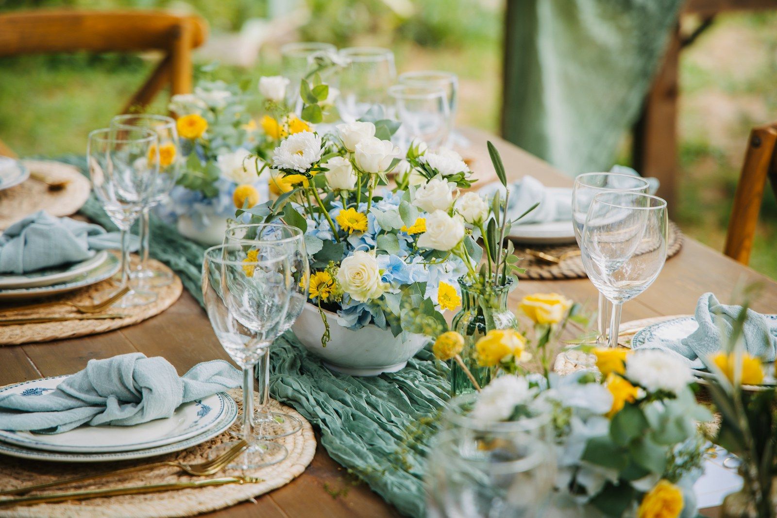 Mesa de celebración al aire libre con flores amarillas y blancas