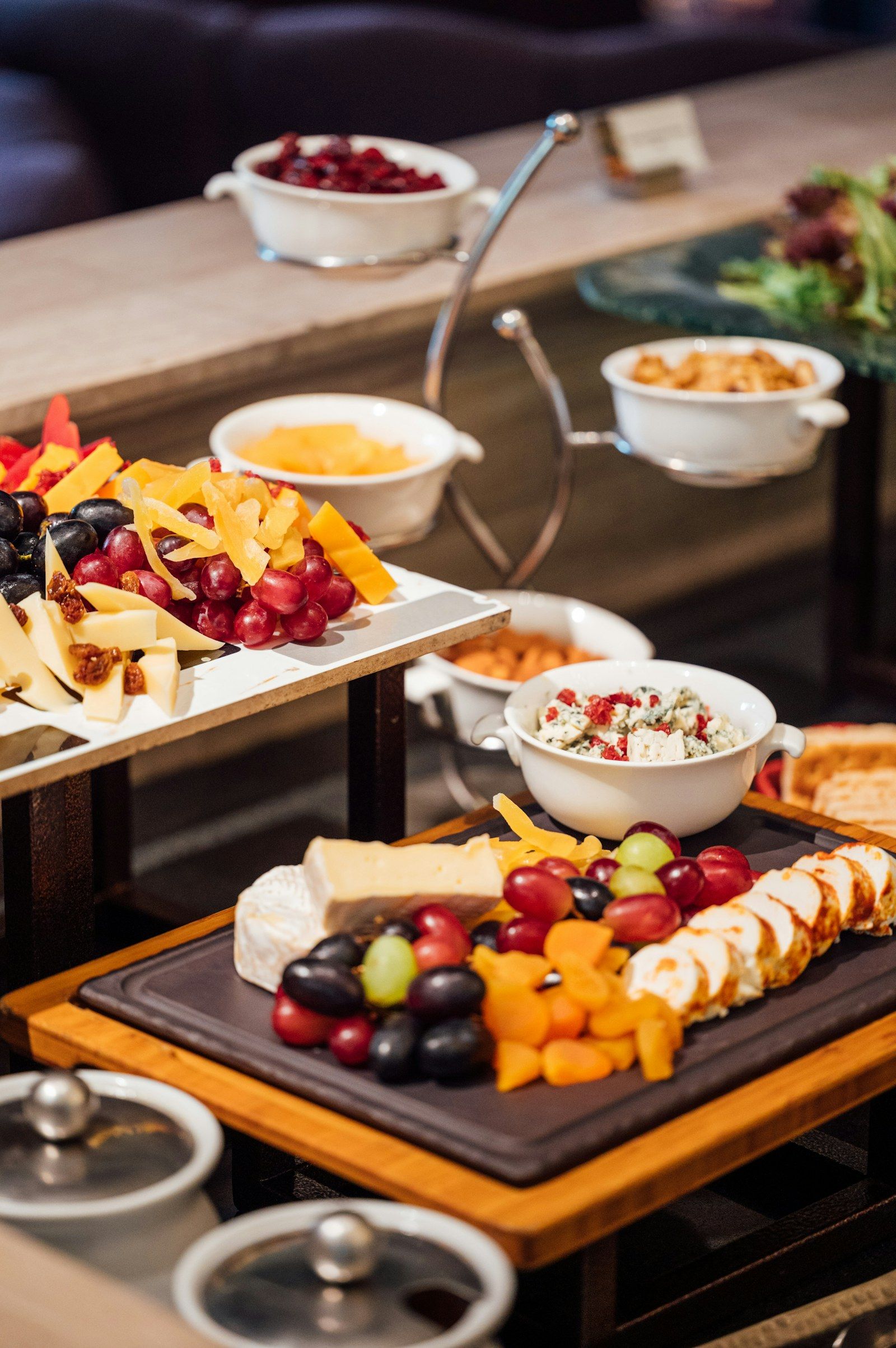 Mesa de bufet con quesos, frutas y bocadillos