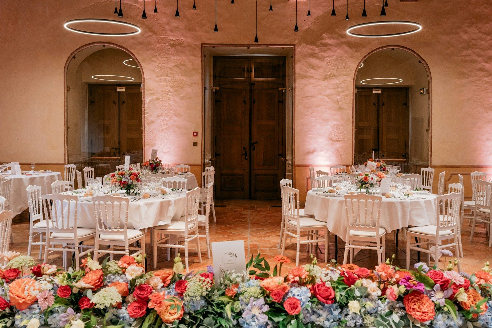 Salón de boda con mesas redondas y abundantes flores de colores