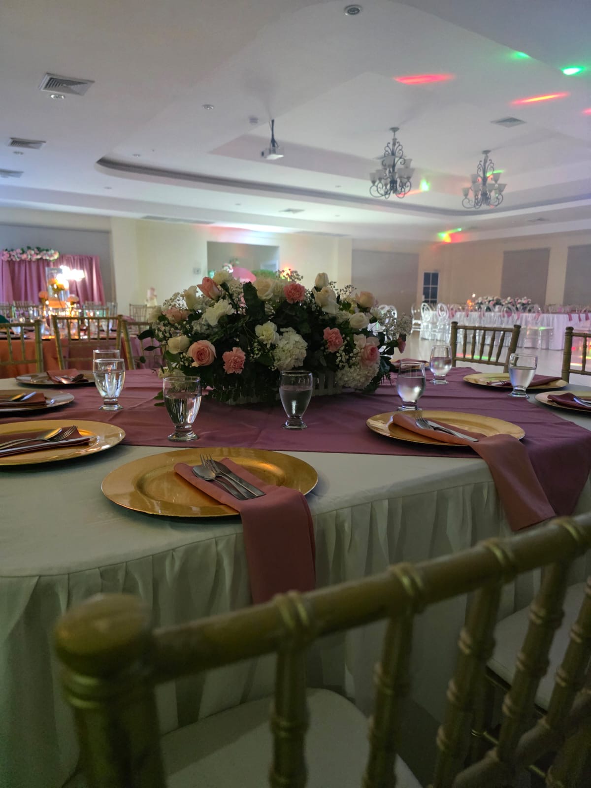 Salón completo con mesas y centros florales rosados