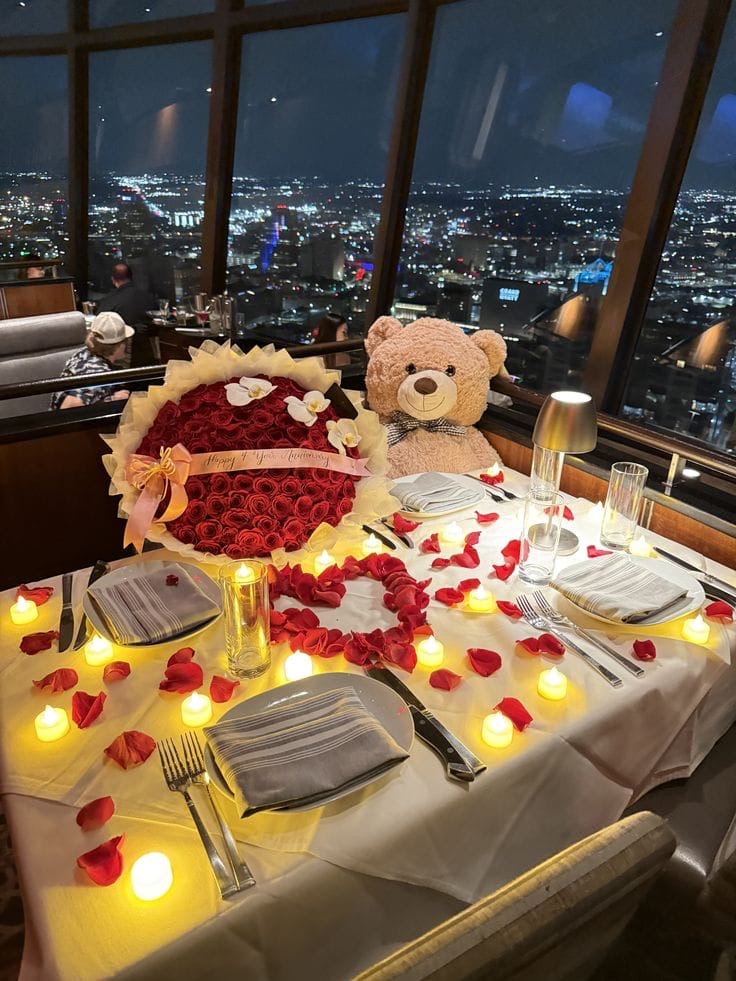 Cena romántica privada con bouquet de rosas rojas y vista de ciudad