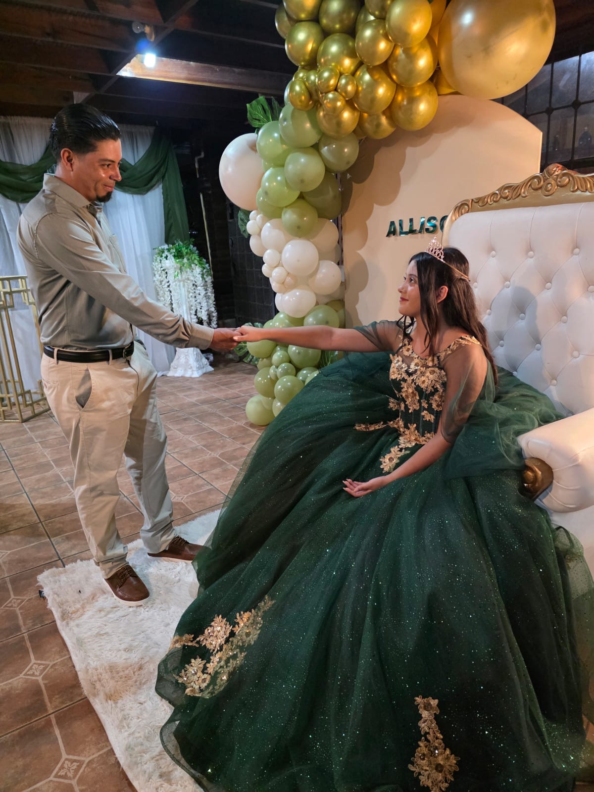 Quinceañera con vestido verde bailando con su padre