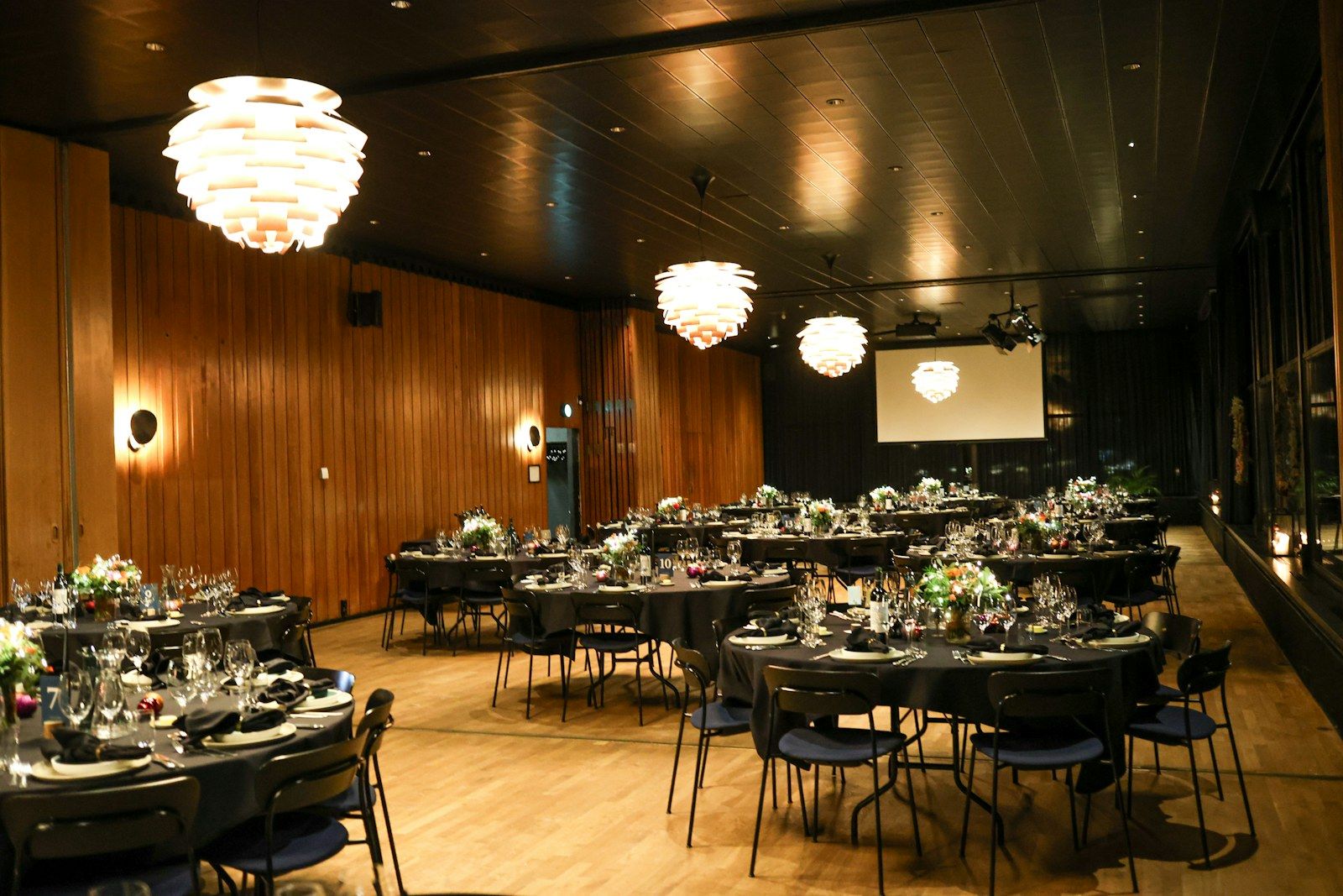 Salón de eventos con mesas redondas para una cena corporativa