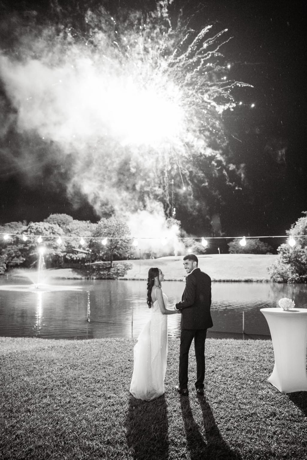 Novios frente al lago con fuegos artificiales