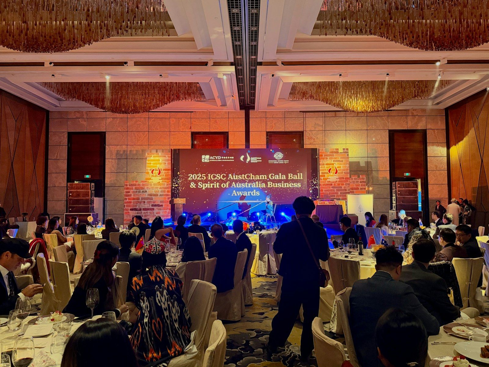 Gala corporativa con escenario e invitados sentados